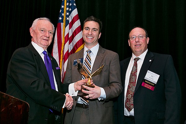 Chuck Corjay (l), past president, and Chris Cusano (r), chapter president, present Ryan Cox with an Emerging Leader Award in December.